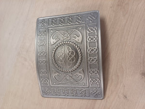 Decorative metal box with intricate Celtic knot patterns on a wooden surface