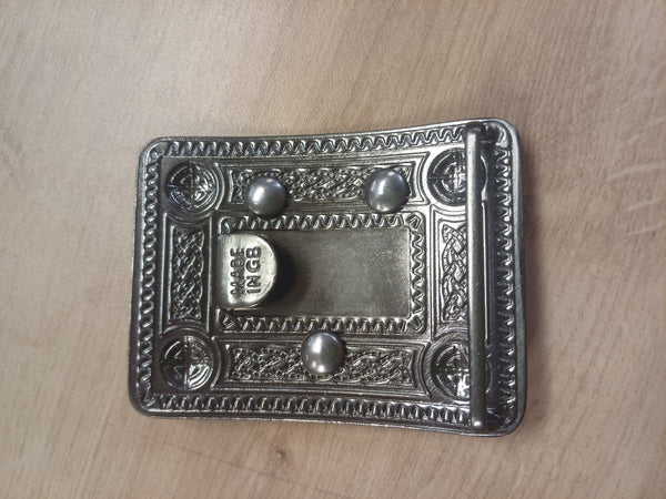 Decorative metal buckle on a wooden surface