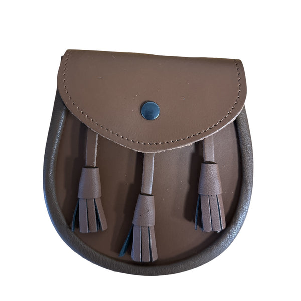 A brown leather sporran with a flap closure secured by a snap button, featuring three leather tassels